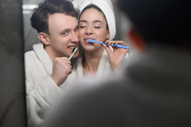 A young married couple brushing their teeth together dental hygiene