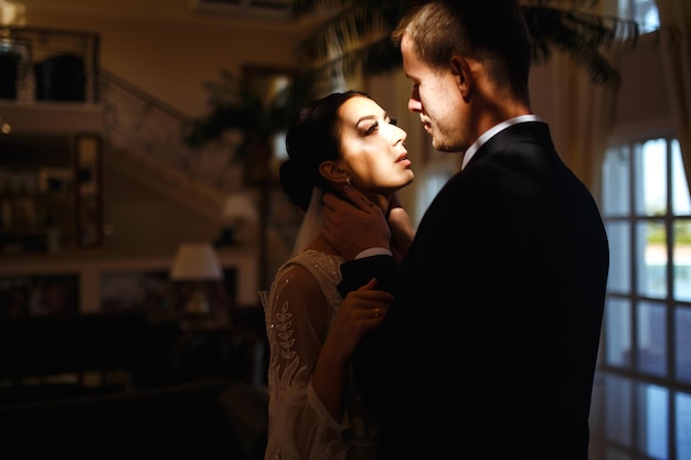 Young married couple in darkness Newlyweds enjoy each other tenderly Intimate atmosphere Romantic
