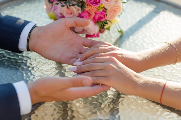 Молодая супружеская пара держится за руки в день свадьбы