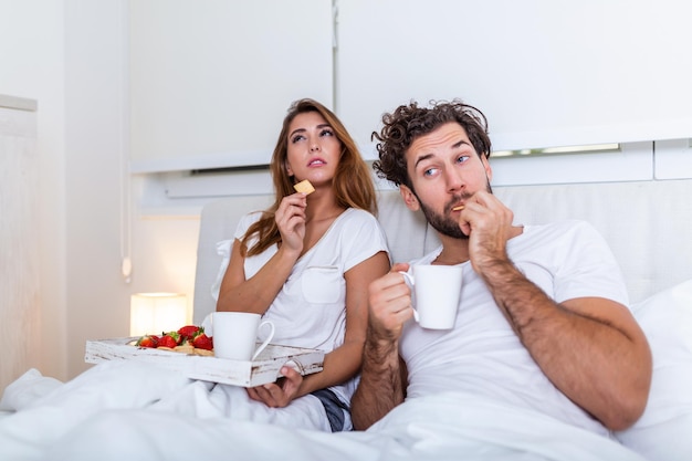 Young married couple in love eating breakfast in their bed.\
good morning! healthy breakfast in bed. young beautiful love couple\
is having breakfast in bed.