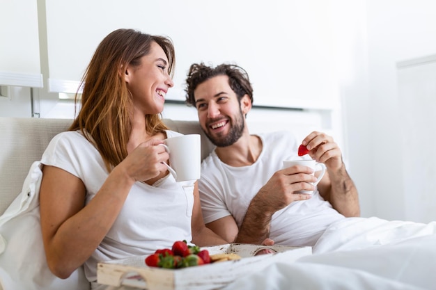 Young married couple in love eating breakfast in their bed.\
good morning! healthy breakfast in bed. young beautiful love couple\
is having breakfast in bed.