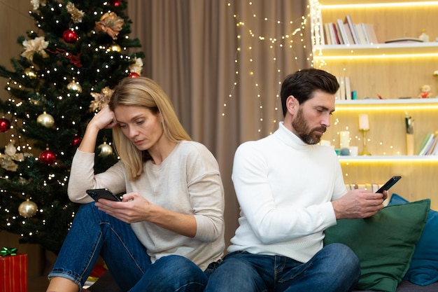 Una giovane coppia sposata un uomo e una donna durante le vacanze di natale e capodanno a cui sono seduti