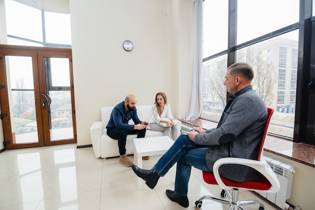 A young married couple of men and women talk to a psychologist
at a therapy session. psychology.