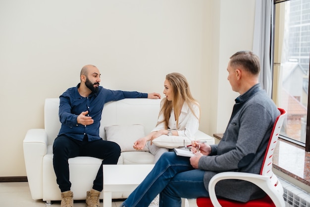 A young married couple of men and women talk to a psychologist at a therapy session. Psychology.