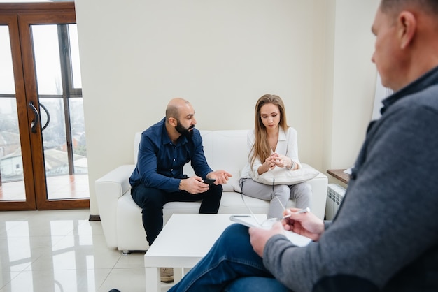 A young married couple of men and women talk to a psychologist at a therapy session