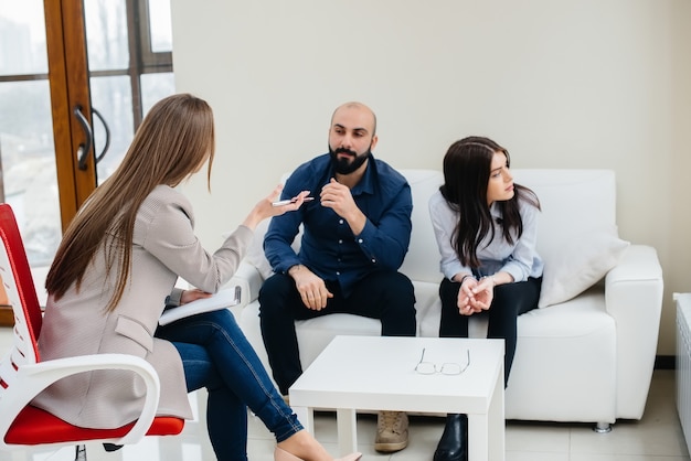 A young married couple of men and women talk to a psychologist at a therapy session