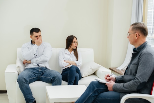 A young married couple of men and women talk to a psychologist at a therapy session