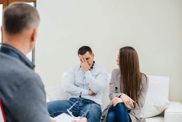 A young married couple talks to a psychologist during a therapy session.