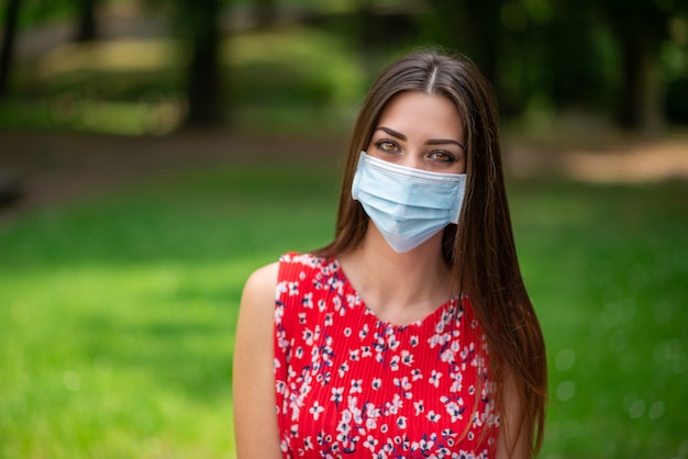 Young masked woman in a park