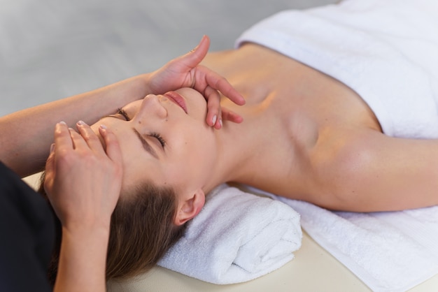 Young masseur making massage for young female client.