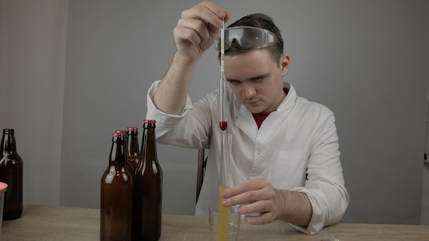 Foto il giovane maestro tecnologo prepara la birra a casa