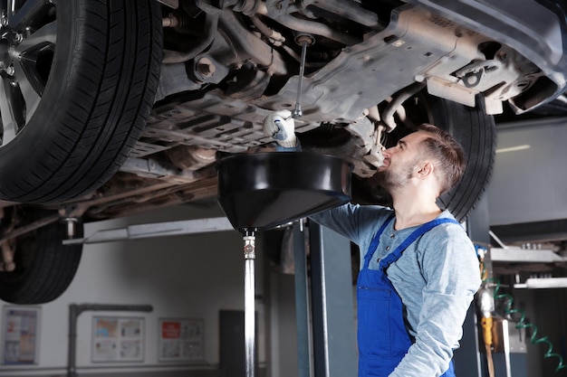 Young mechanic fixing car in service