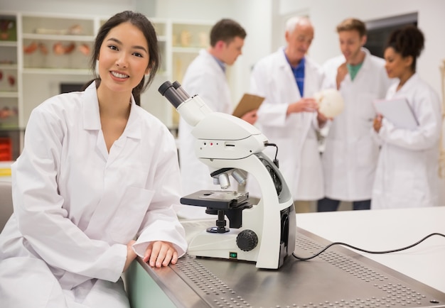 Young medical student working with microscope