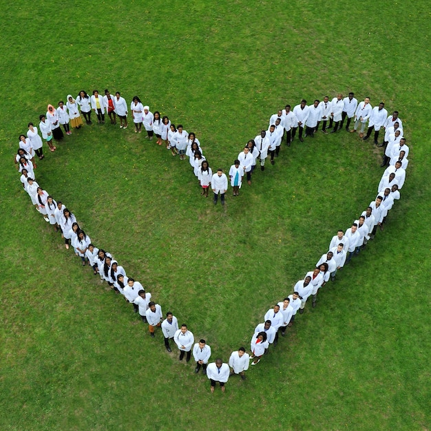 Giovani studenti di medicina in piedi a terra, facendo grande cuore di carità.