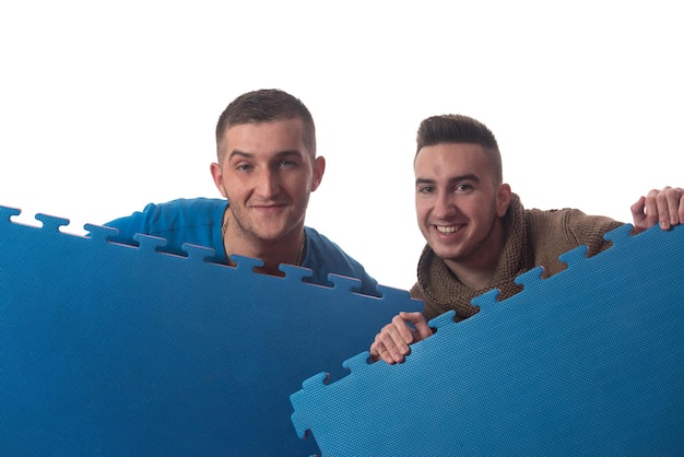 Young Men Holding Blue Tatami Mat Puzzle