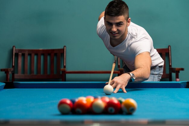 Young Men Lining To Hit Ball On Pool Table