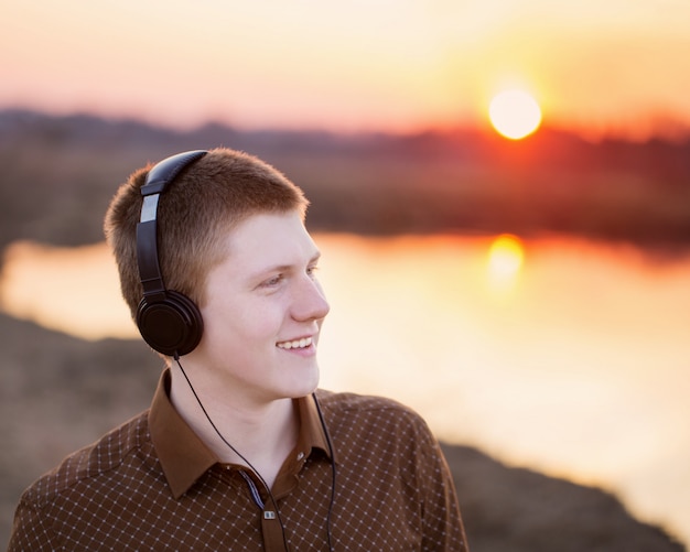 Молодые люди слушают музыку в наушниках на открытом воздухе