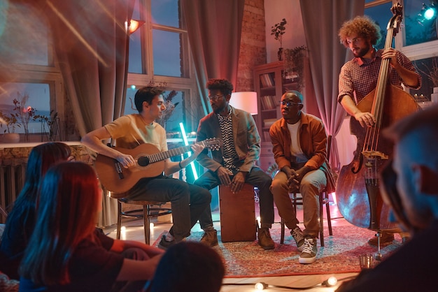 Young men playing musical instruments performing for their fans in the studio