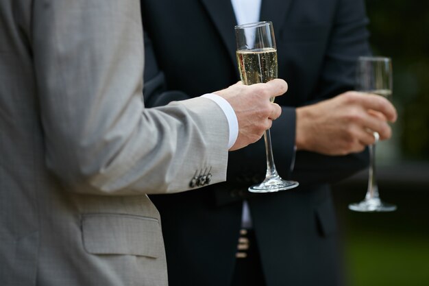 Young men in suit holding glass of champagne
