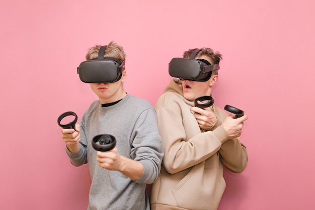 Young men with controller and VR helmets playing video games