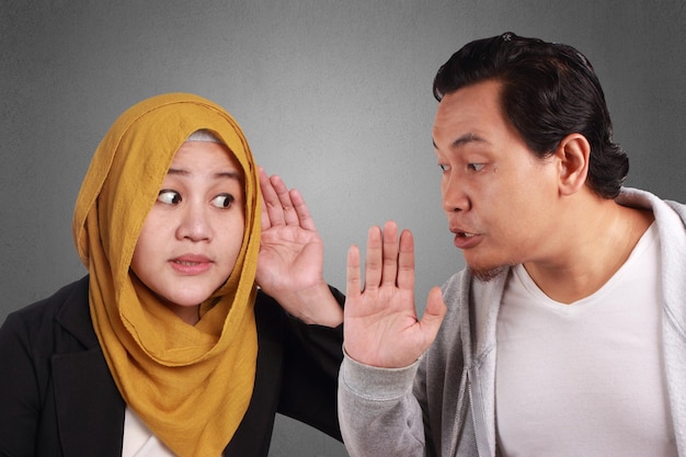 Young Men and women asian muslim wisper on each other