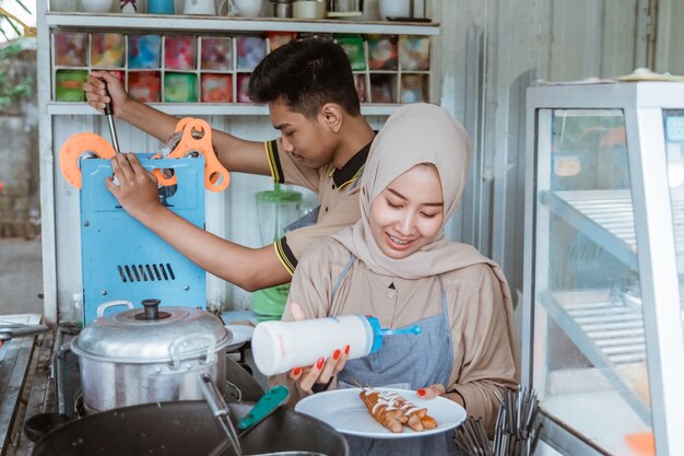 Young men and women muslim who are preparing dish ordered by customer