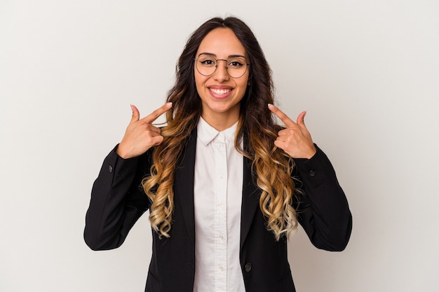 Young mexican business woman isolated on white background smiles, pointing fingers at mouth.