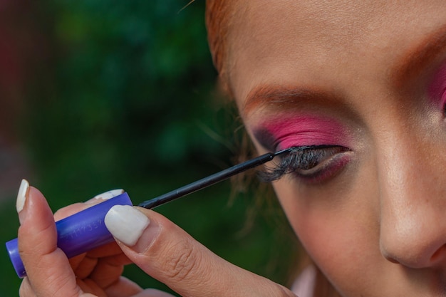 A young Mexican dancer adjusts her dress and prepares her makeup for a traditional dance