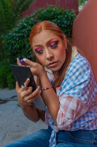 A young mexican dancer adjusts her dress and prepares her\
makeup for a traditional dance