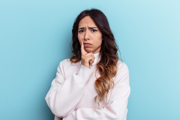 Young mexican woman isolated on blue background unhappy looking in camera with sarcastic expression.