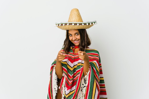 Young mexican woman isolated on white wall cheerful smiles pointing to front