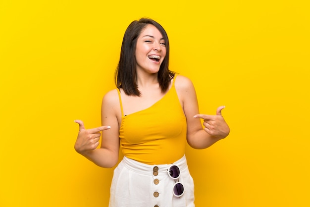 Young Mexican woman over isolated yellow background proud and self-satisfied