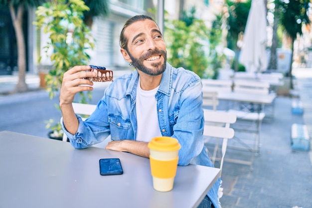 コーヒーショップのテラスで朝食をとる中東の若い男性