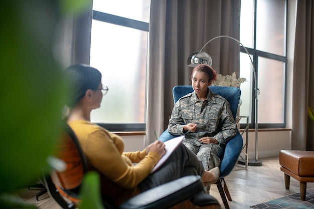 Foto giovane donna militare che parla con uno psicoterapeuta