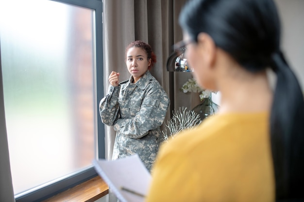 写真 心理療法士と話している若い軍の女性