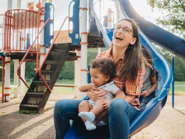 Photo young millennial mother and diverse toddler boy bonding together outdoors at local park