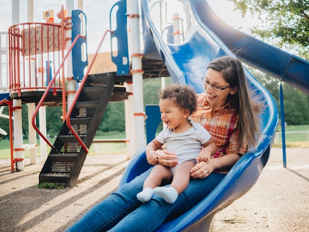 Photo young millennial mother and diverse toddler boy bonding together outdoors at local park