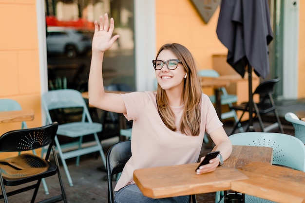 Young millennial woman using phone in cafe