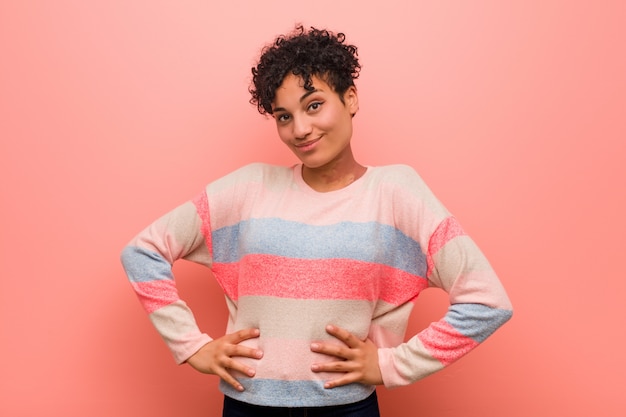 Young mixed african american teenager woman confident keeping hands on hips.