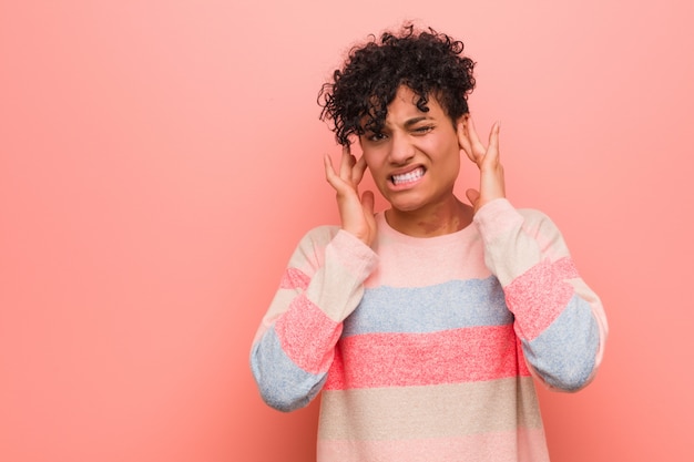 Young mixed african american teenager woman covering ears with hands.