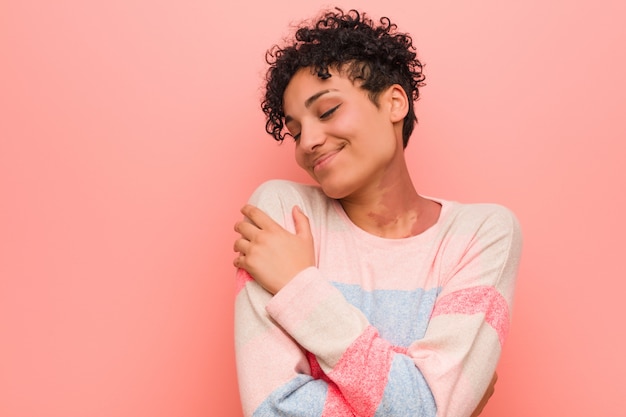 Young mixed african american teenager woman hugs, smiling carefree and happy.