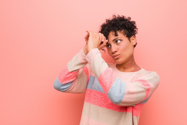 Young mixed african american teenager woman looking far away keeping hand on forehead