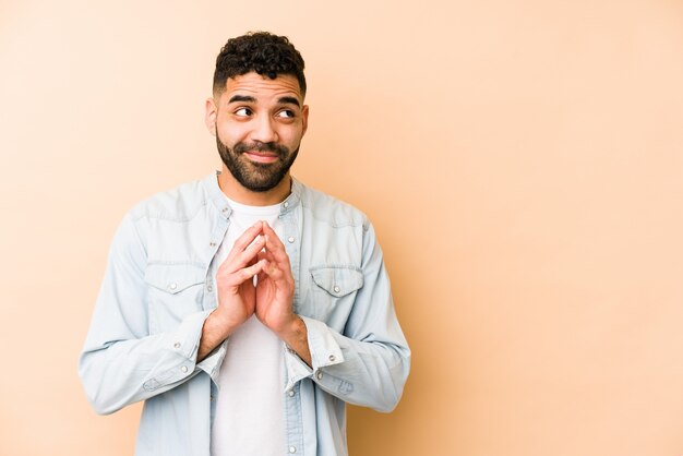 Young mixed race arabic man isolated making up plan in mind, setting up an idea.