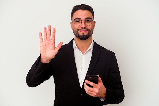 Young mixed race business man holding a mobile phone man isolated on white background smiling cheerful showing number five with fingers.