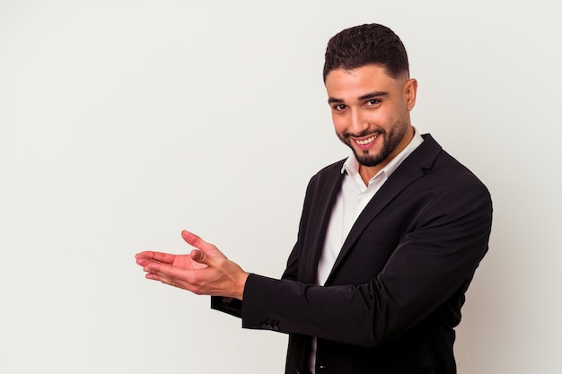 Young mixed race business man isolated on white background holding a copy space on a palm.