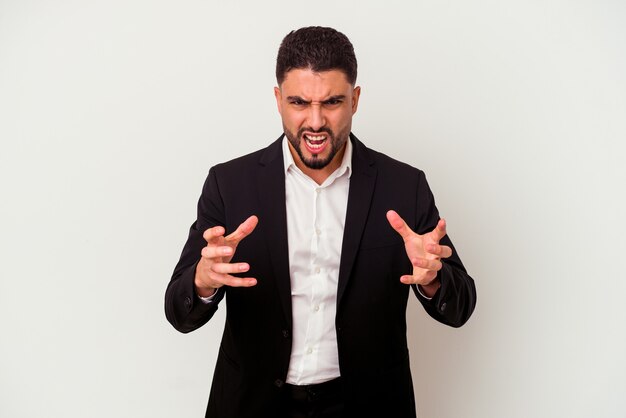 Young mixed race business man isolated on white background upset screaming with tense hands.