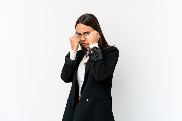 Young mixed race business woman isolated on white background throwing a punch, anger, fighting due to an argument, boxing.