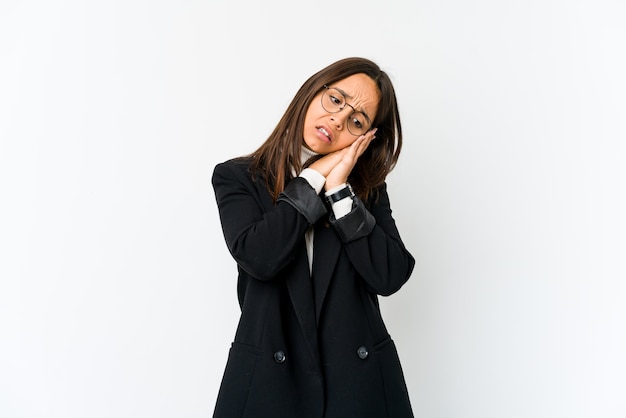 Young mixed race business woman isolated on white wall yawning showing a tired gesture covering mouth with hand.