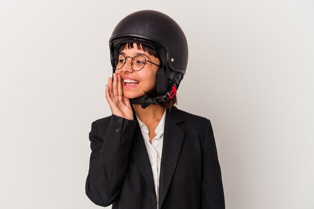 Young mixed race business woman wearing a motorbike helmet isolated shouting and holding palm near opened mouth.