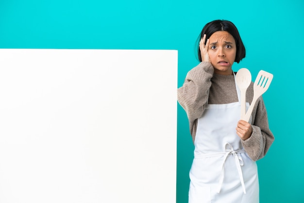 Photo young mixed race cook woman with a big placard isolated on blue background doing nervous gesture